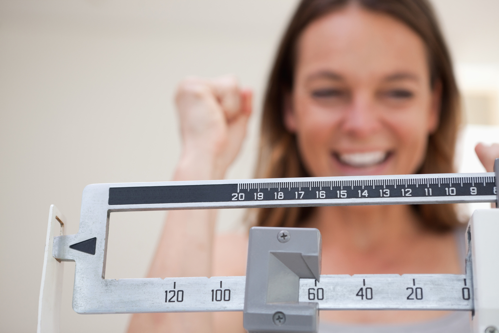 Scale showing weight loss to smiling woman
